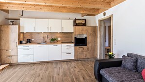 A modern kitchen with wooden cabinets, a black oven, and a sink.