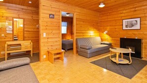 Ein gemütliches Holzhaus-Interieur mit einer Couch, einem kleinen Tisch und einem Kamin.
