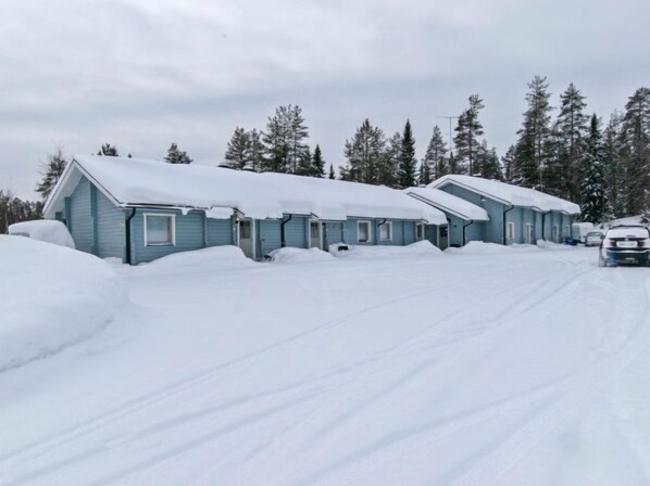 Cabins nestled among evergreen trees, offering a serene winter retreat.