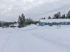 Un paisaje nevado con un edificio y árboles.