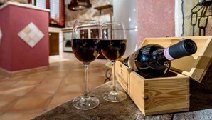 A wooden wine box with two wine glasses on a stone countertop.