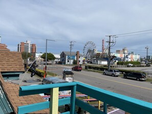 A street view with a parking sign, a Ferris wheel, and various buildings in the background.