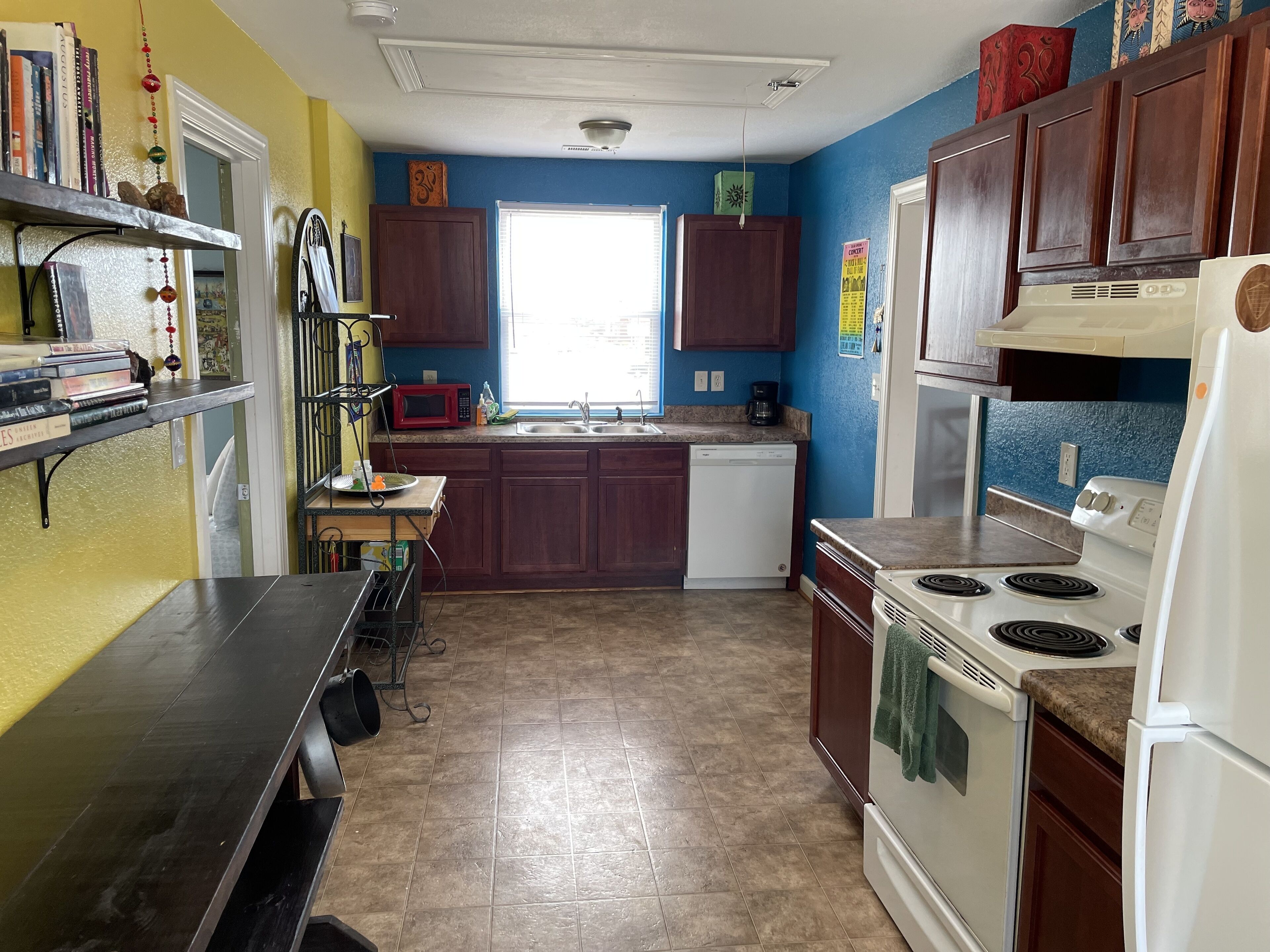 A kitchen with wooden cabinets, a microwave, a sink, a stove, and a refrigerator.