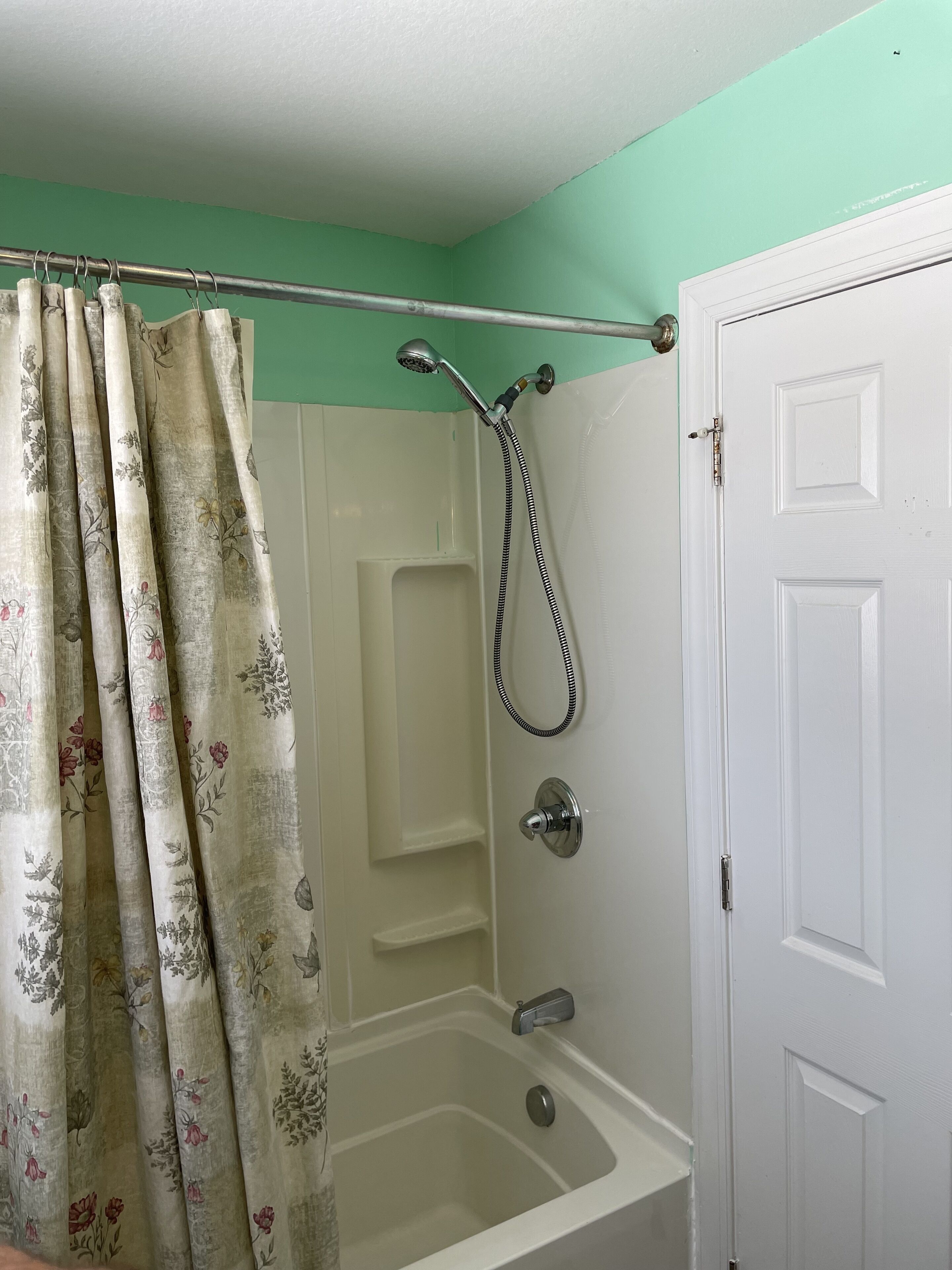 A bathroom with a shower, a bathtub, and a door.