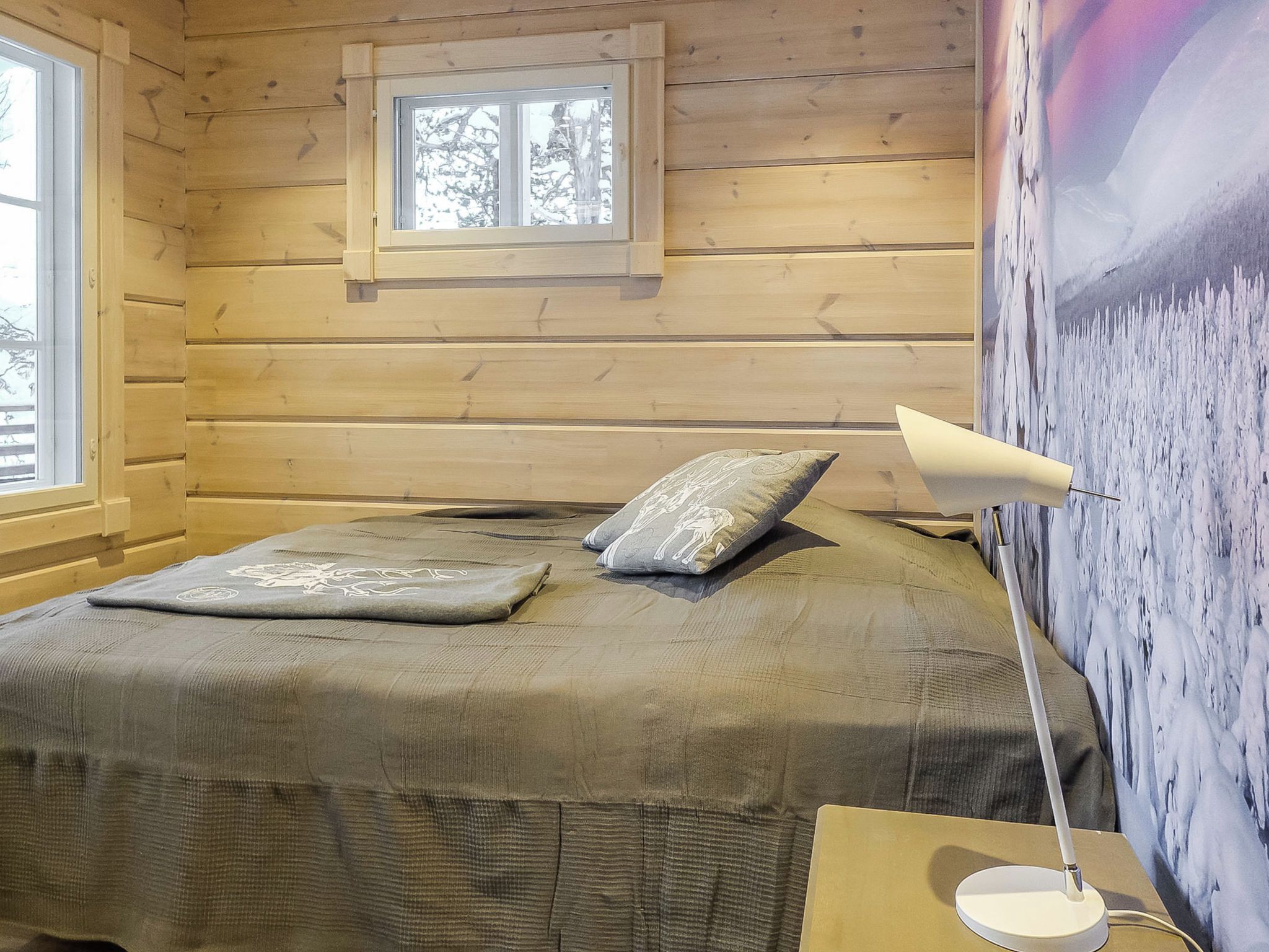 A room with a bed, pillows, a lamp, and a window.