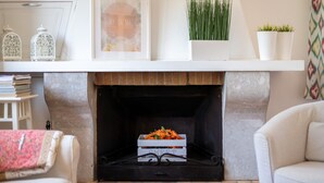 A fireplace with a white mantel, a framed picture, and a small plant. - Holiday Home "Es Viola" with Mountain Views, Pool, Wi-Fi, Garden and Terrace (Santa Eugènia)
