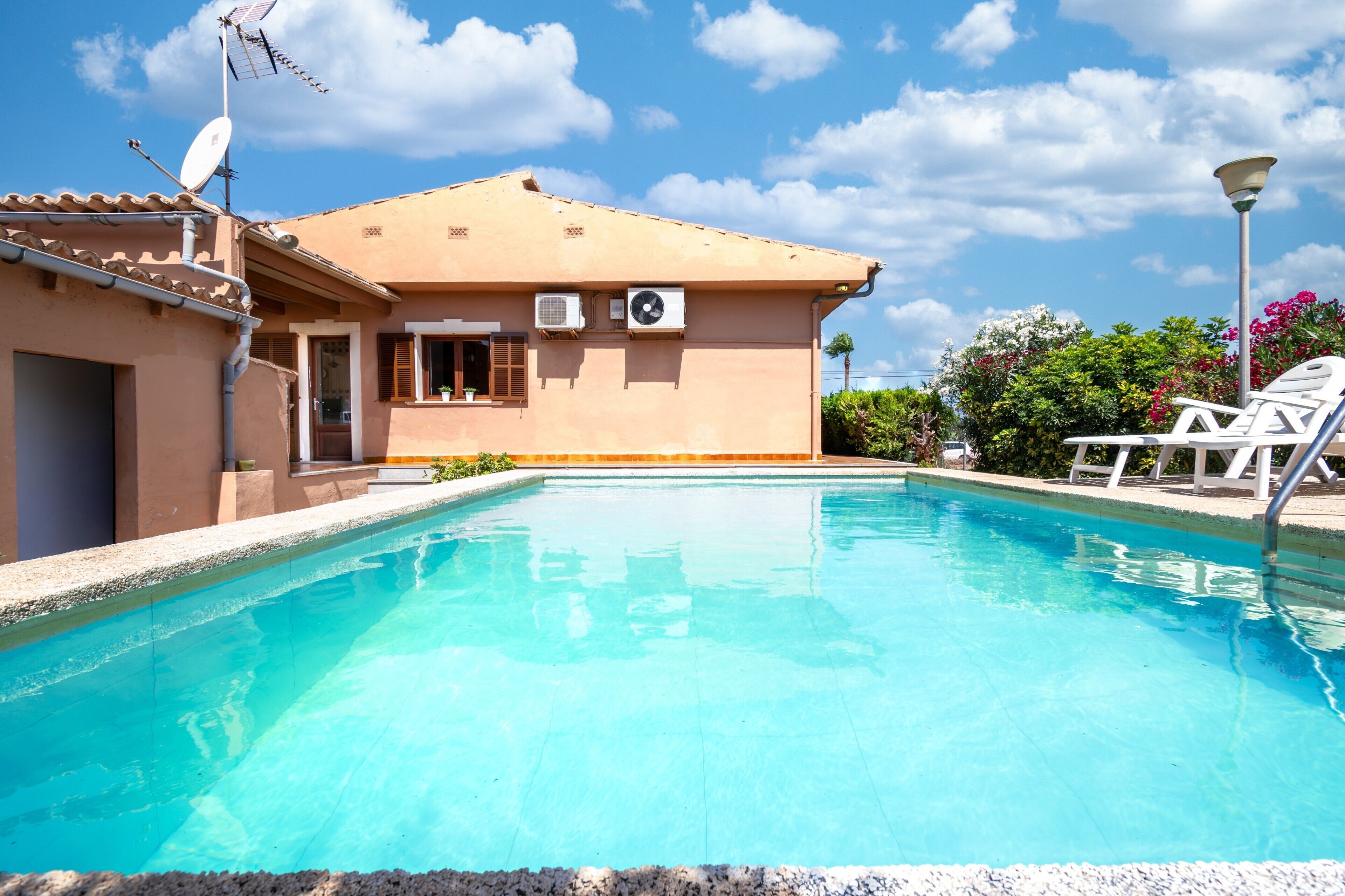 A swimming pool with a house in the background.