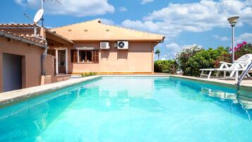 A swimming pool with a house in the background.