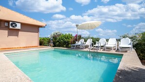 A swimming pool with white lounge chairs and a ceiling fan. - Holiday Home "Es Viola" with Mountain Views, Pool, Wi-Fi, Garden and Terrace (Santa Eugènia)