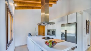 A modern kitchen with a central island, stainless steel appliances, and a wooden ceiling. - Holiday Finca Can Salat Selva with Pool, Garden & Wi-Fi (Selva)