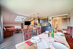 Un intérieur moderne comprenant un coin repas, une cuisine et un espace de vie.