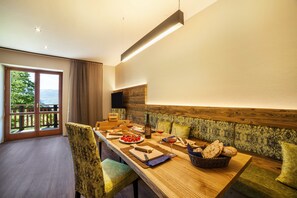 Un espace repas avec une table en bois, des chaises et une vue sur l’extérieur.