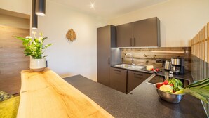 Une cuisine moderne avec un plan de travail en bois, des appareils en acier inoxydable et une plante en pot.