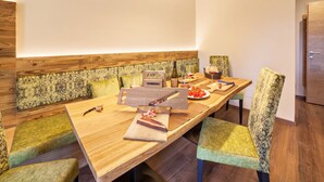 Un espace de salle à manger moderne avec une longue table en bois, des chaises rembourrées et une tête de lit en bois.