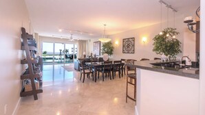 A spacious kitchen with a dining area, large windows, and a view of the outdoors.