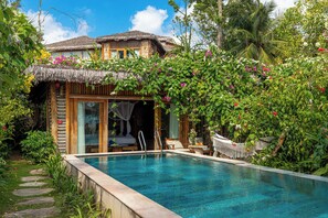 A pool area with a thatched-roof structure, a wooden deck, and lush greenery. - Ocean Bay Phu Quoc Resort and Spa (Phu Quoc)