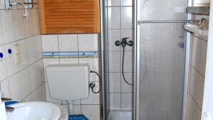 A bathroom with a toilet, sink, and shower. - Ferienhaus Schmidt, Erika - Ferienhaus 7 (Mönkebude)