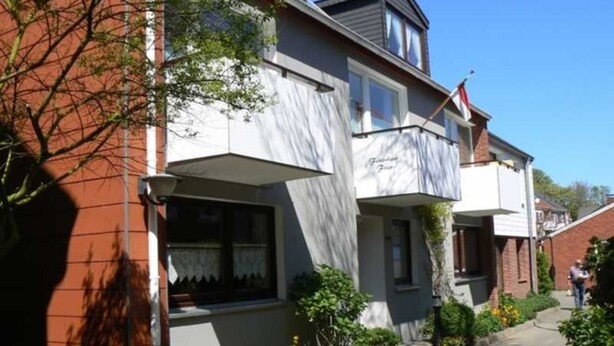 Un immeuble de deux étages avec un balcon au deuxième étage.