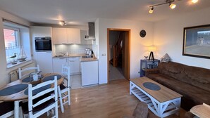 A compact living space with a kitchenette, dining area, and seating area.
