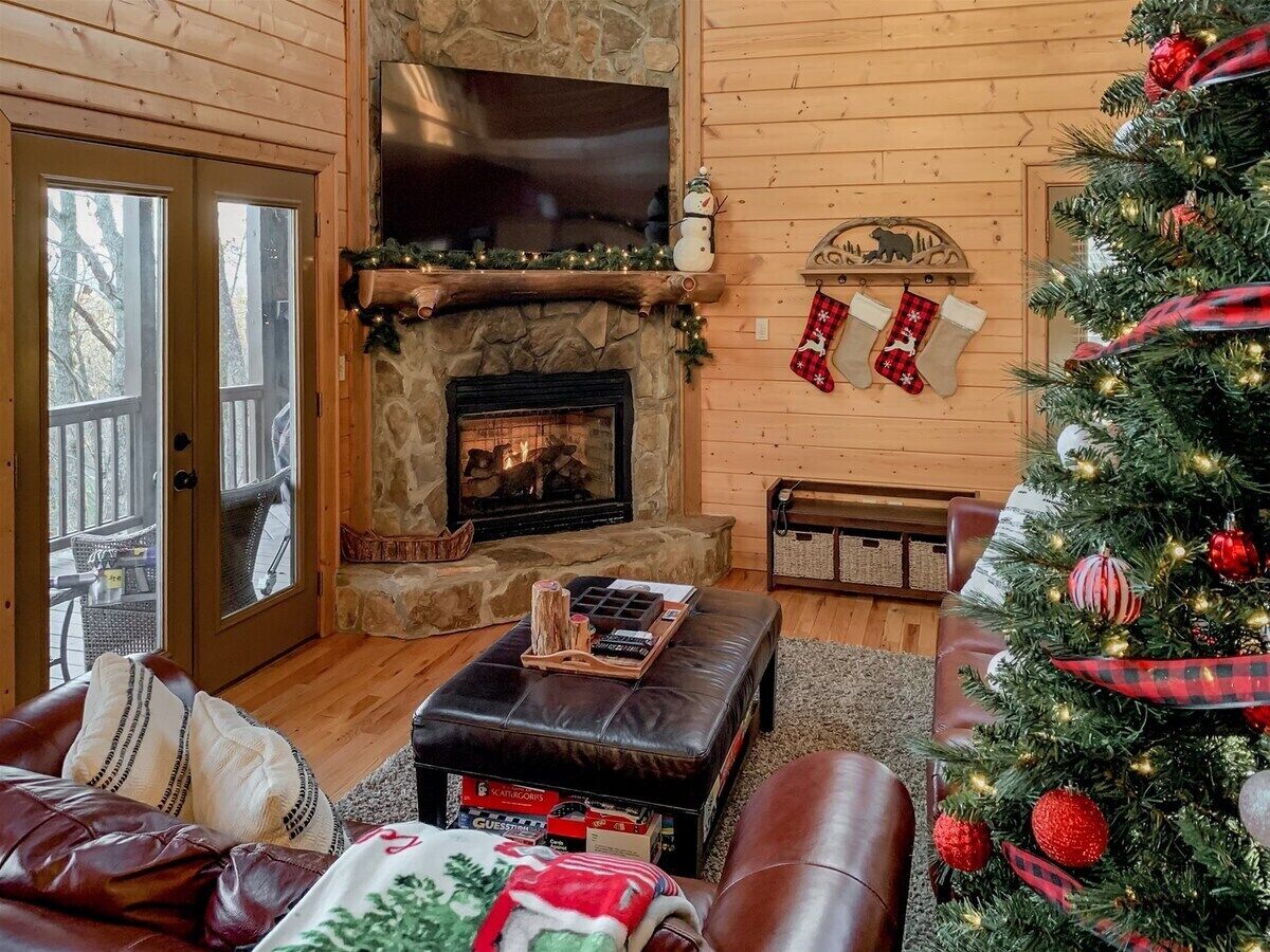 Een gezellige woonkamer met een open haard, een kerstboom en feestdecoraties.