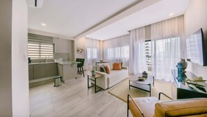 Een moderne woonkamer met een bank, salontafel en een eethoek.