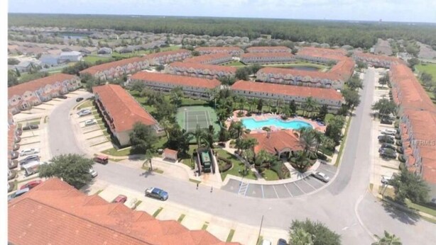 Uma área residencial com várias casas, uma piscina e uma quadra de tênis.