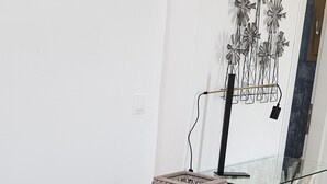 Comedor con mesa de vidrio, sillas de metal y una escultura decorativa de metal.