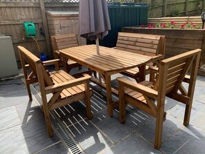 Relax outdoors with a patio set featuring a central table and four chairs.