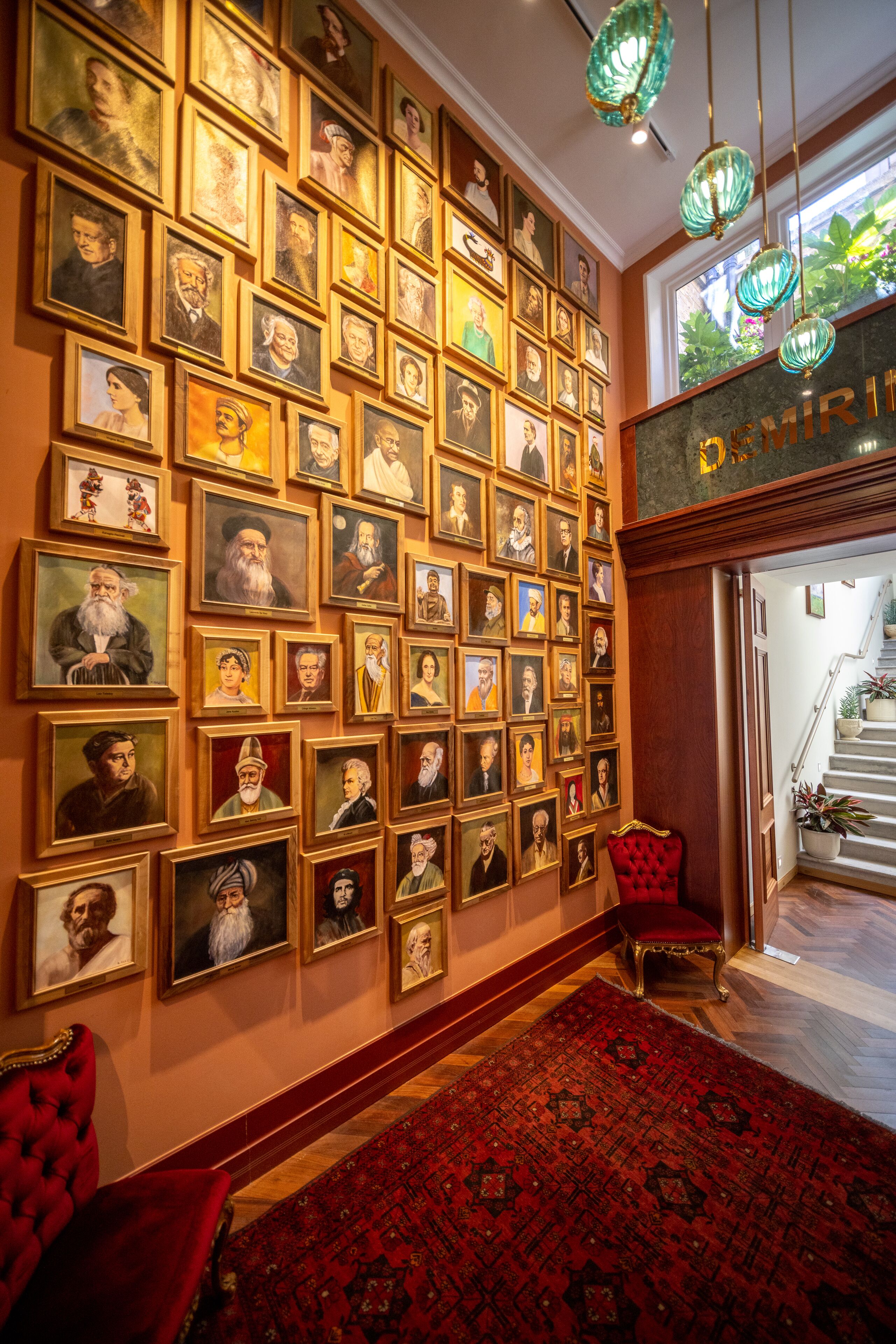 A wall of framed portraits in a hotel lobby.
