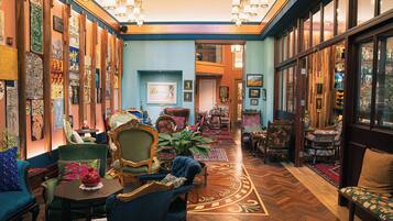 A spacious, elegantly decorated lounge area with a variety of seating options, including plush sofas and armchairs, arranged around a central coffee table.