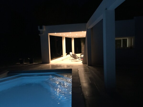Relax by the pool surrounded by sleek architecture and comfortable lounge chairs.