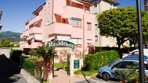 Ein rosafarbenes Mehrfamilienhaus mit dem Schild "Residence".