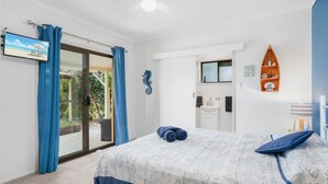 Un dormitorio con cama, baño y vistas al exterior.