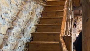 Eine Holztreppe mit einer Steinmauer an der Seite.