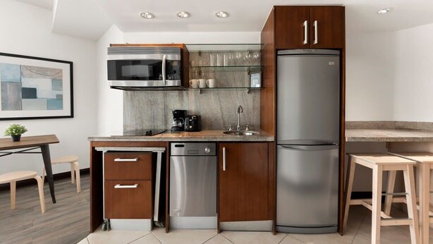 A modern kitchen with a dishwasher, microwave, and refrigerator.