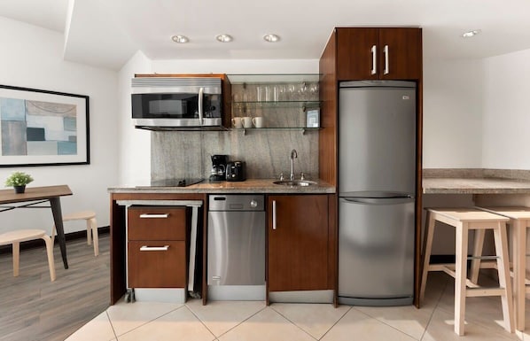 Uma cozinha moderna com máquina de lavar louça, micro-ondas e frigorífico.