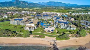 A resort with multiple buildings, a swimming pool, and a beach.
