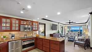 A modern kitchen with stainless steel appliances, wooden cabinets, and a large island.