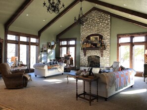 Cozy living room with a large stone fireplace, two sofas, and a wooden coffee table.