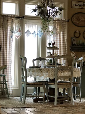 Enjoy meals in this classic dining area with a round table, comfortable chairs, and a chandelier.