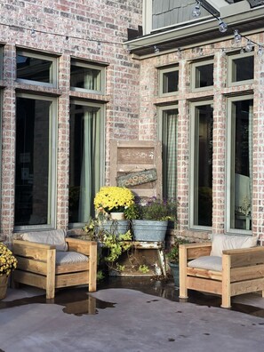 Sit comfortably on the benches in front of the large windows, surrounded by lush greenery and vibrant flowers.