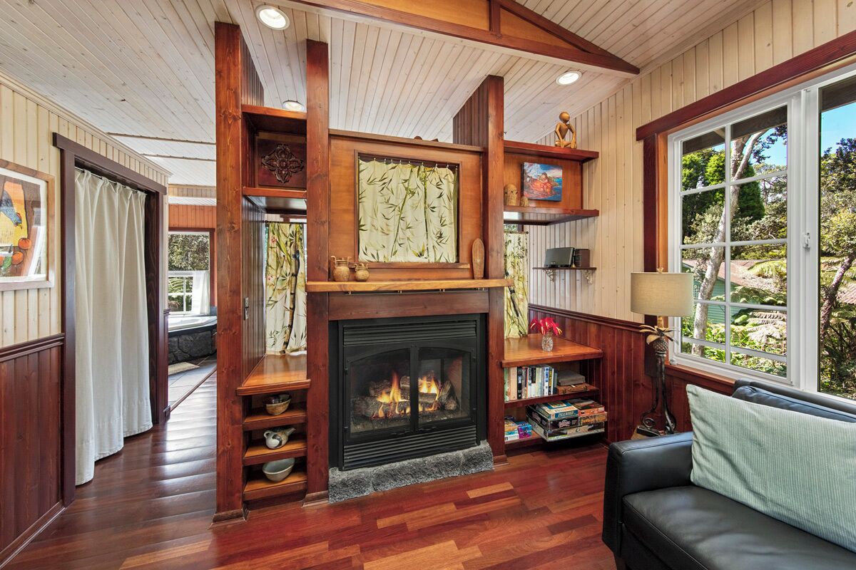 A cozy living room with a fireplace, wooden shelves, and a comfortable seating area.