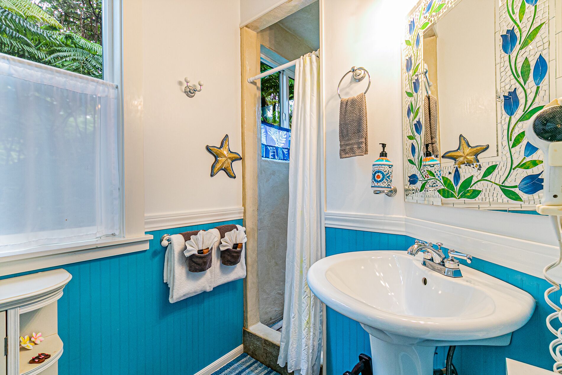 A bathroom with a white sink, blue walls, and a shower area.