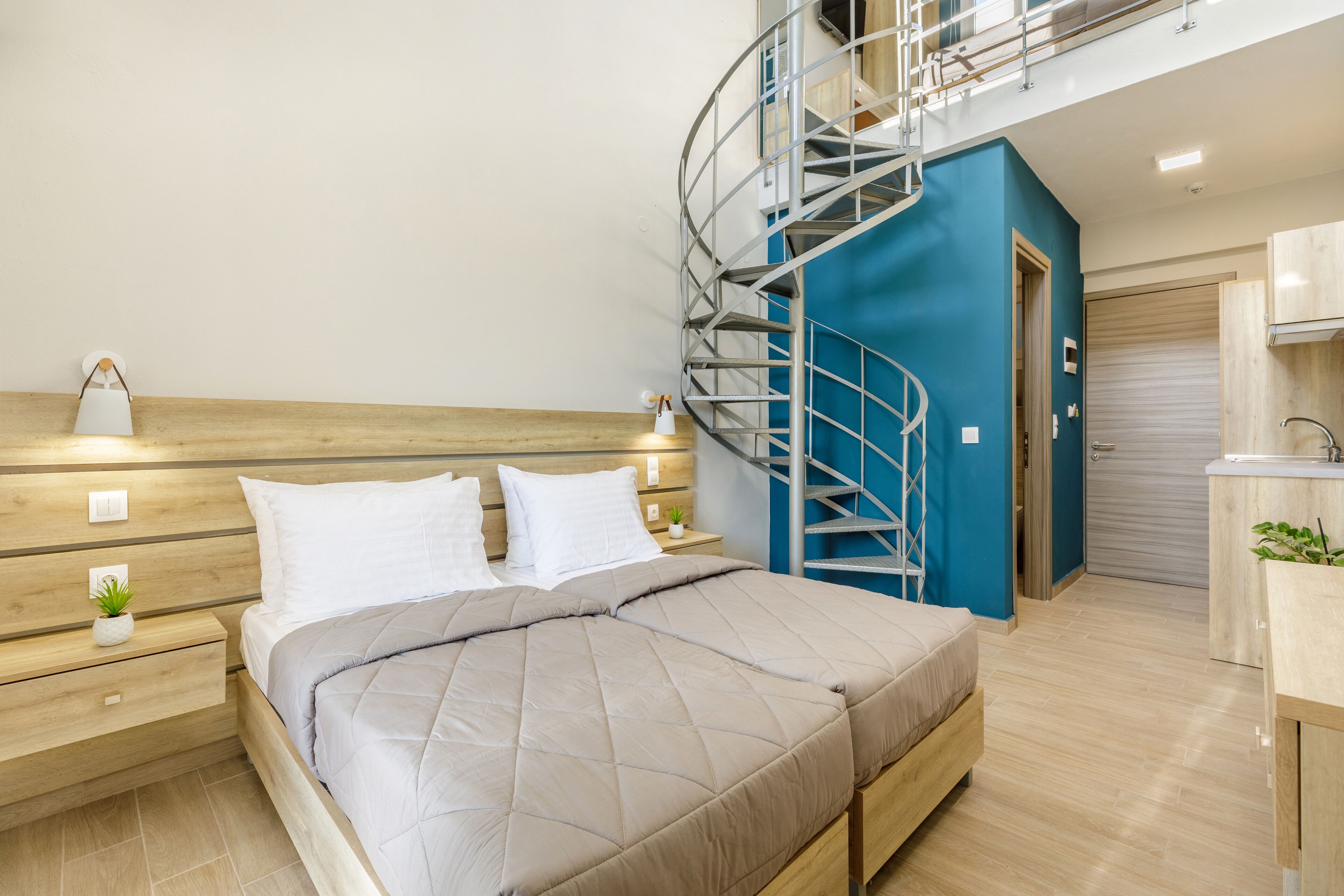 A modern bedroom with a wooden bed, a nightstand, a small plant, and a blue spiral staircase leading to an upper level.