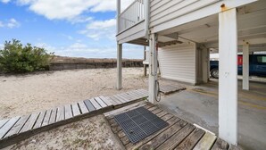 Una proprietà fronte spiaggia con una zona esterna coperta, un pontile in legno e un veicolo sullo sfondo.