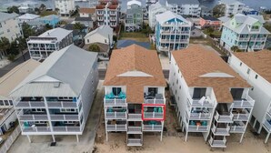 Una zona residenziale costiera con edifici a più piani, balconi e un porto turistico sullo sfondo.