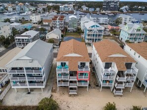 A coastal residential area with multi-story buildings, balconies, and a marina in the background.