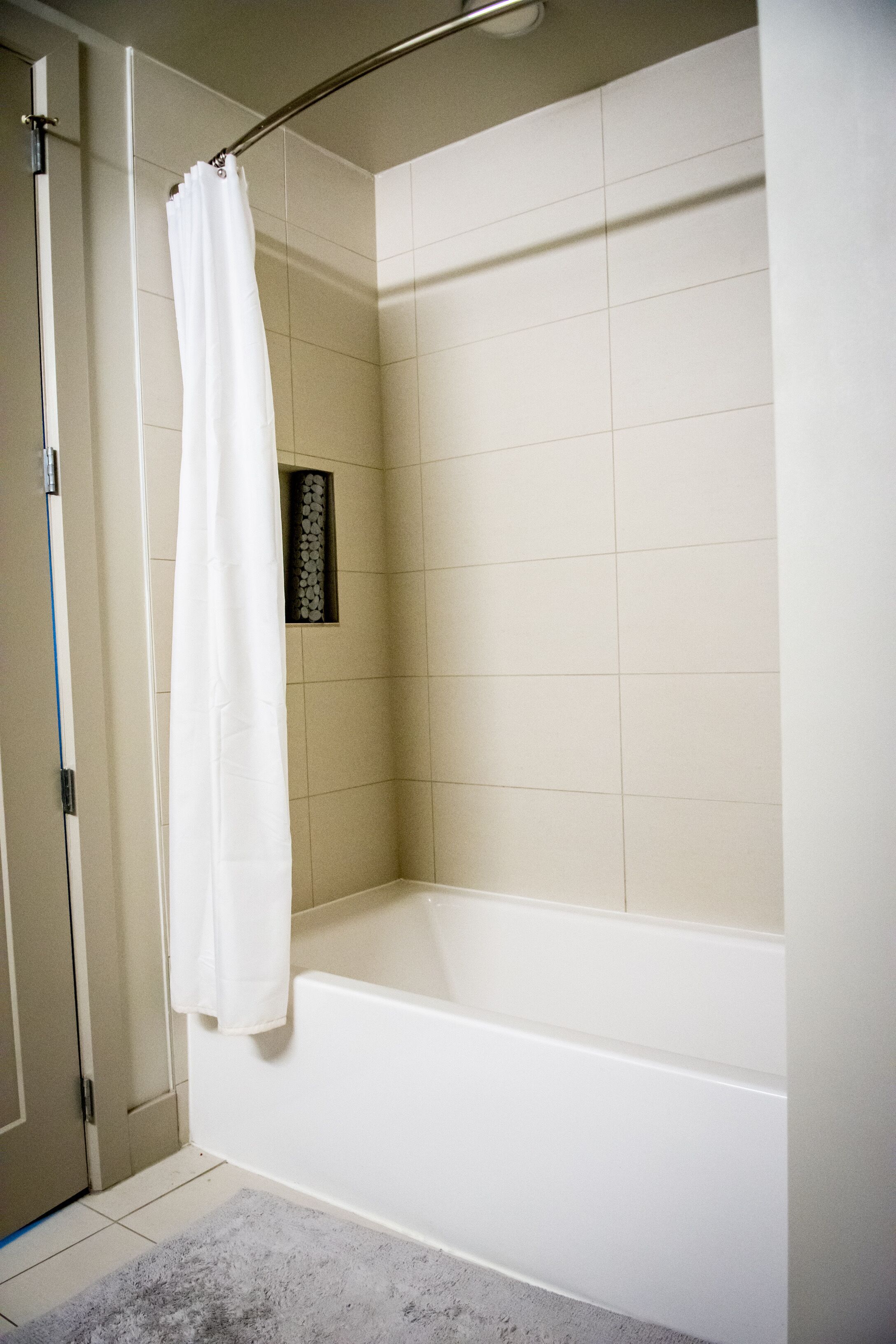 A bathroom with a shower, a bathtub, and a tiled floor.