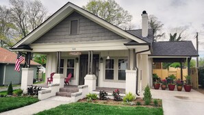 A two-story house with a porch, a chimney, and a mailbox.