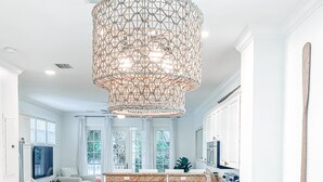 A modern kitchen with white cabinetry, a wooden island, and a large woven pendant light. - Oceanside Getaway: Beautiful Home with Boat Slip, Pool & Beach - Gated community (Islamorada)